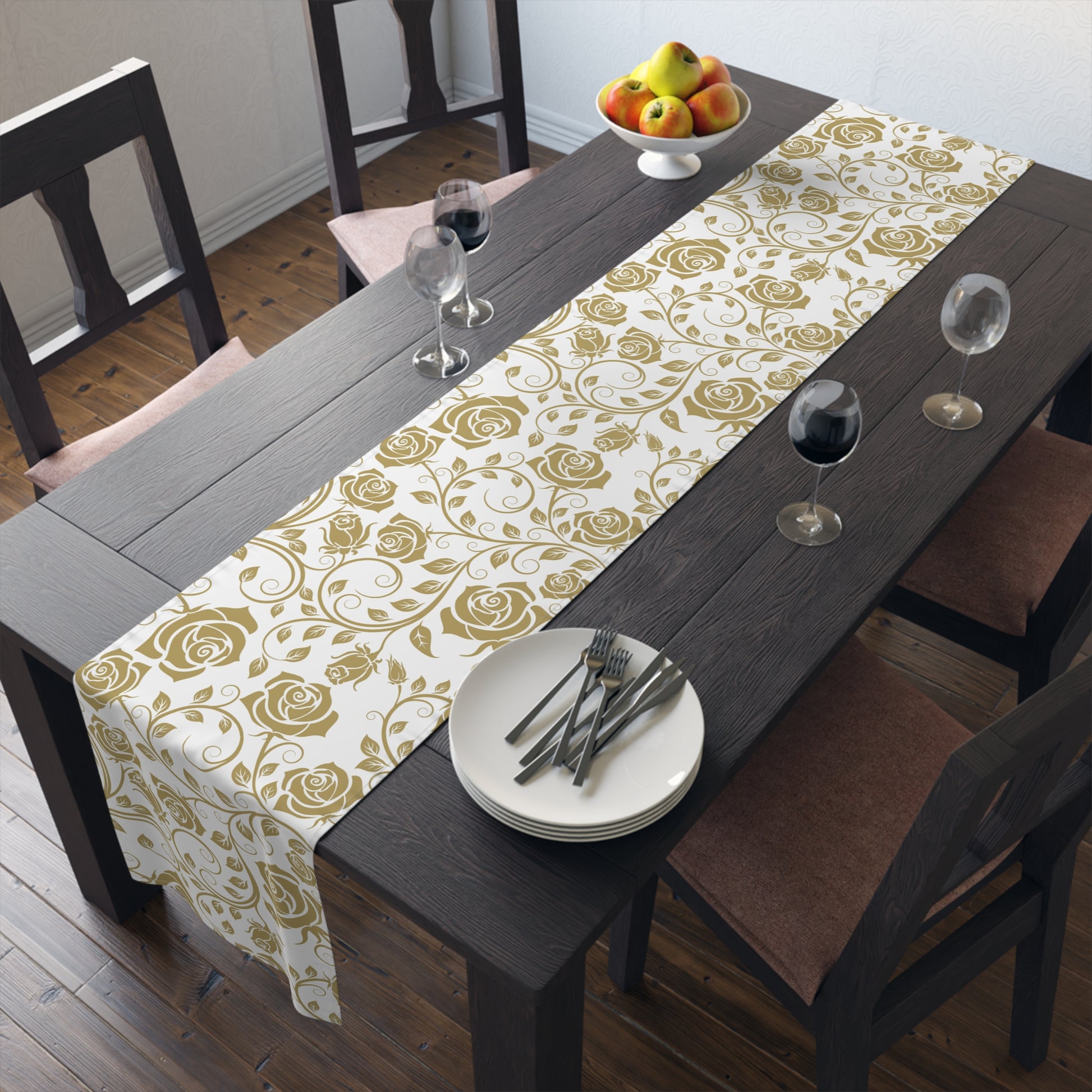 Dining table with a gold floral table runner, plates, and glasses in a home setting.