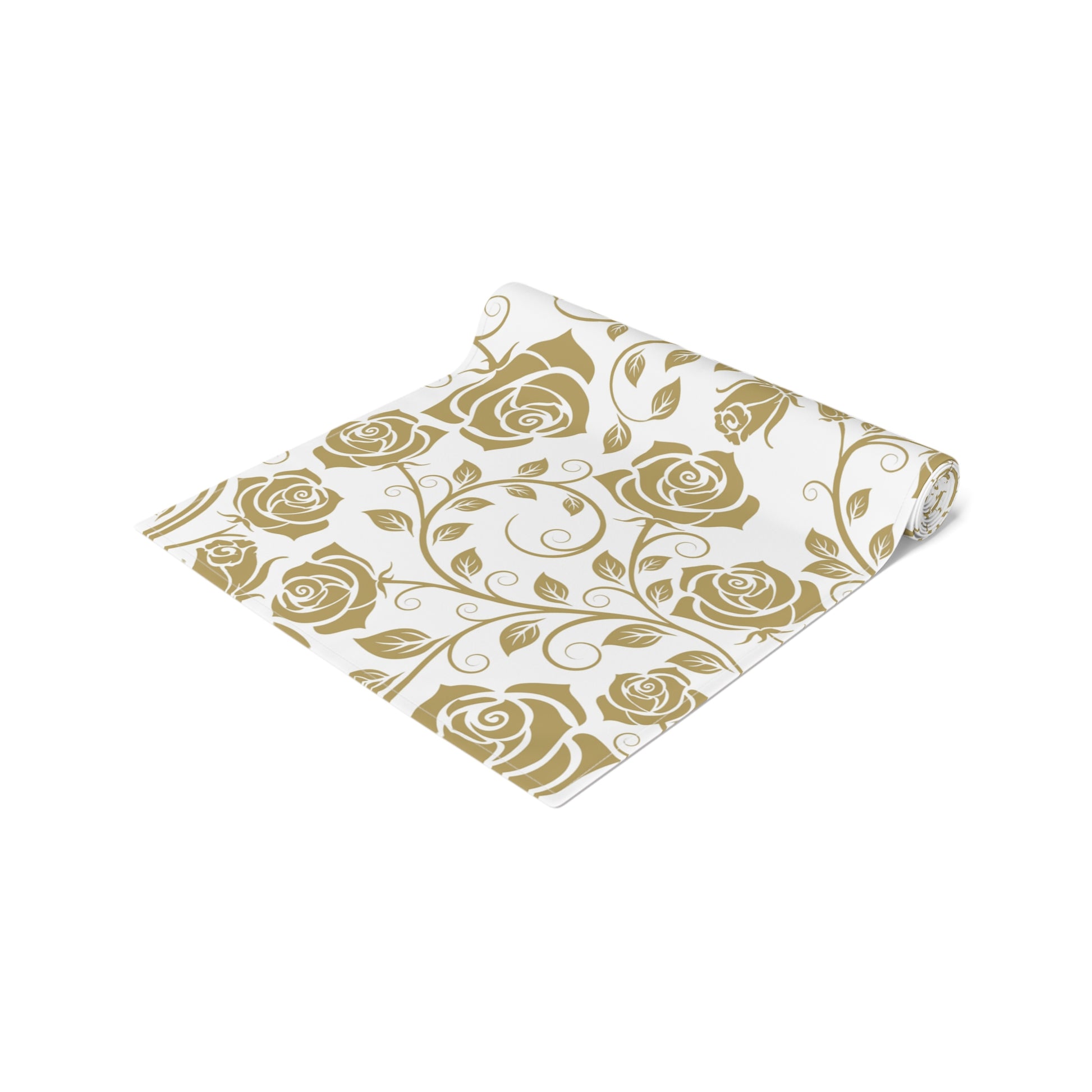 Gold floral patterned table runner with gold roses rolled up on a white background