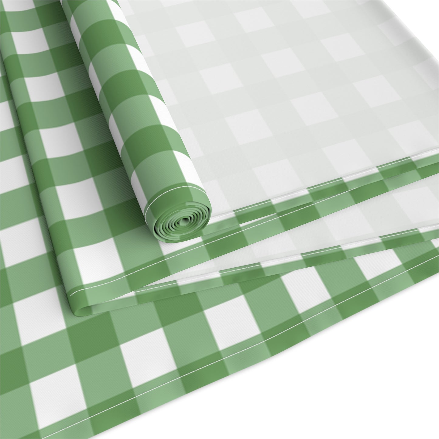 Green gingham checkered table runner with green and white gingham pattern printed on front of table runner, rolled and folded up on a white background.