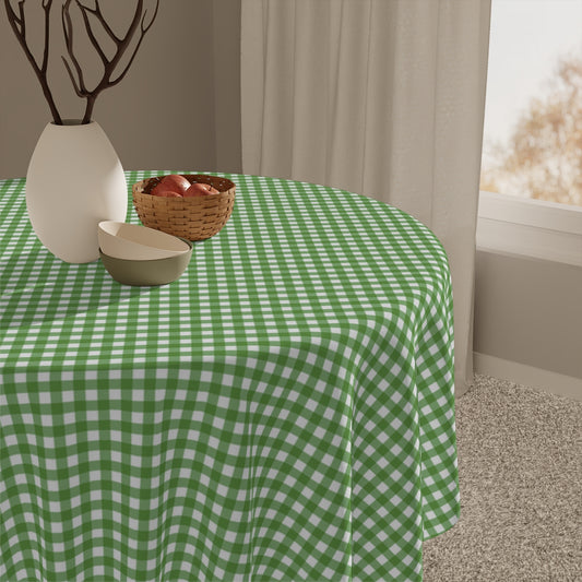 Green and white gingham checkered tablecloth on a round table with decorative items.