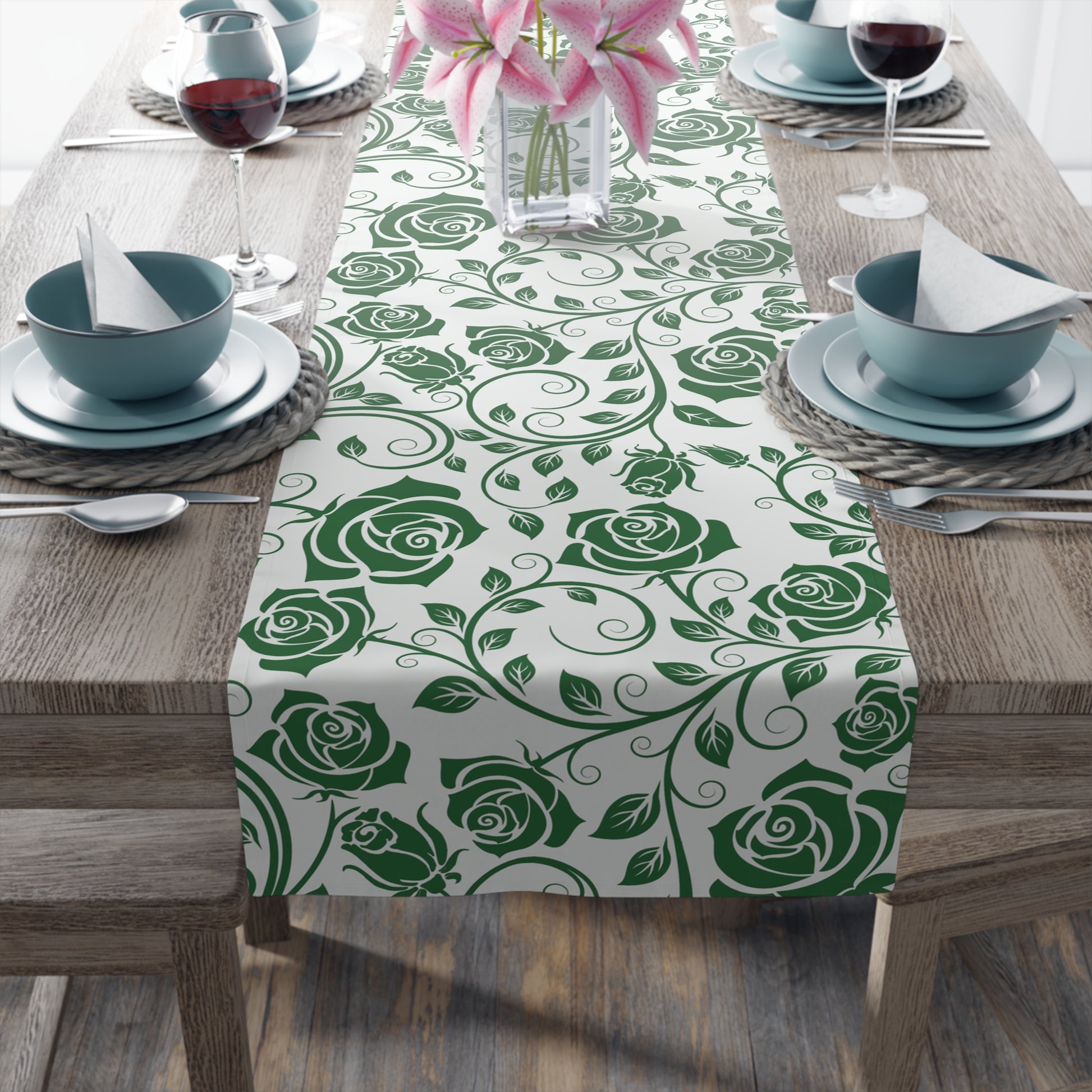Table setting with a green rose pattern table runner on a wooden table.