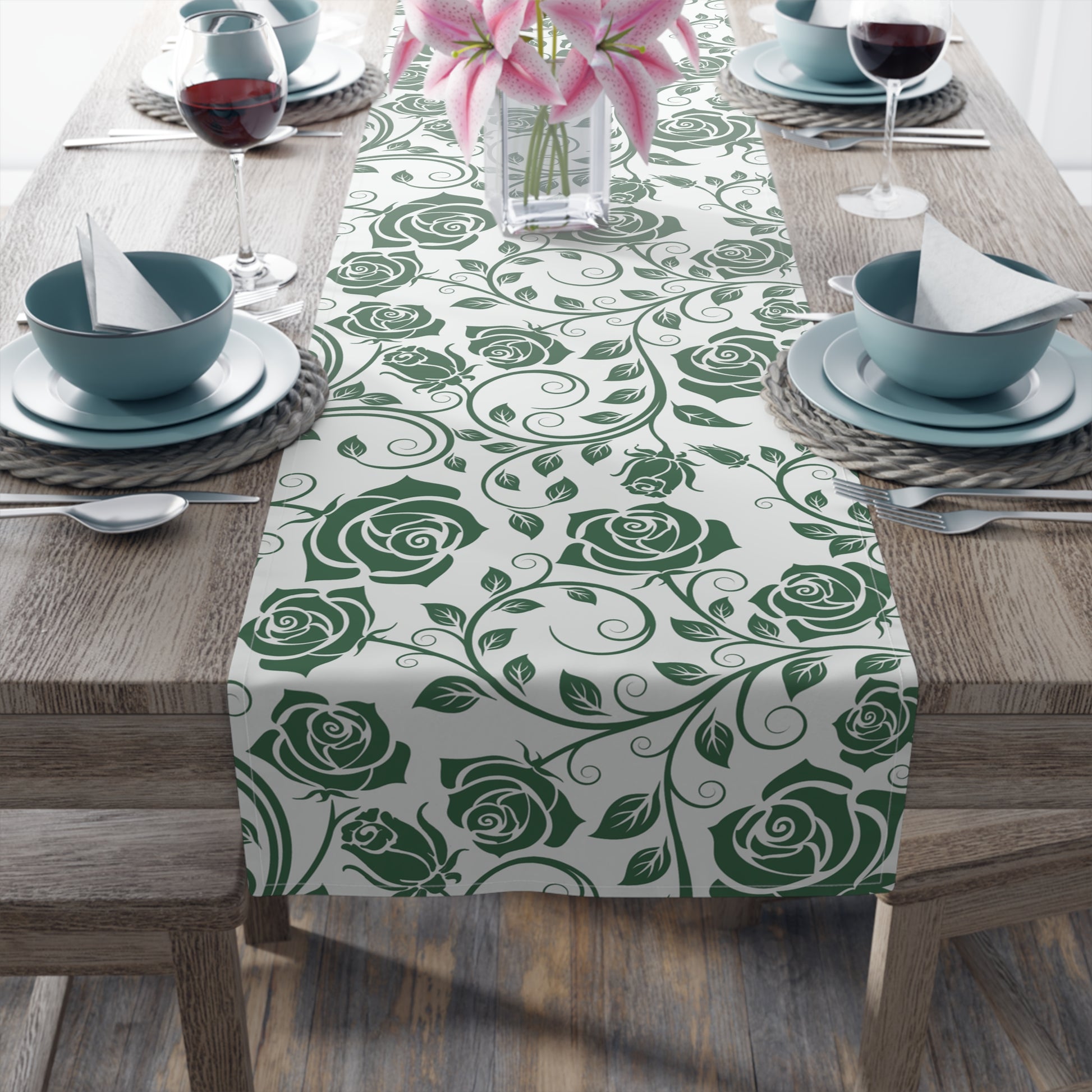 Table setting with a green rose patterned table runner on a wooden table.