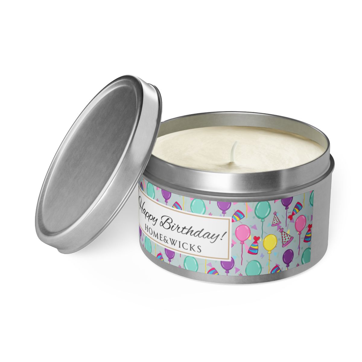 Open silver candle tin with cotton wick and a 'Happy Birthday' label with colorful balloon, birthday hats and confetti design on white background