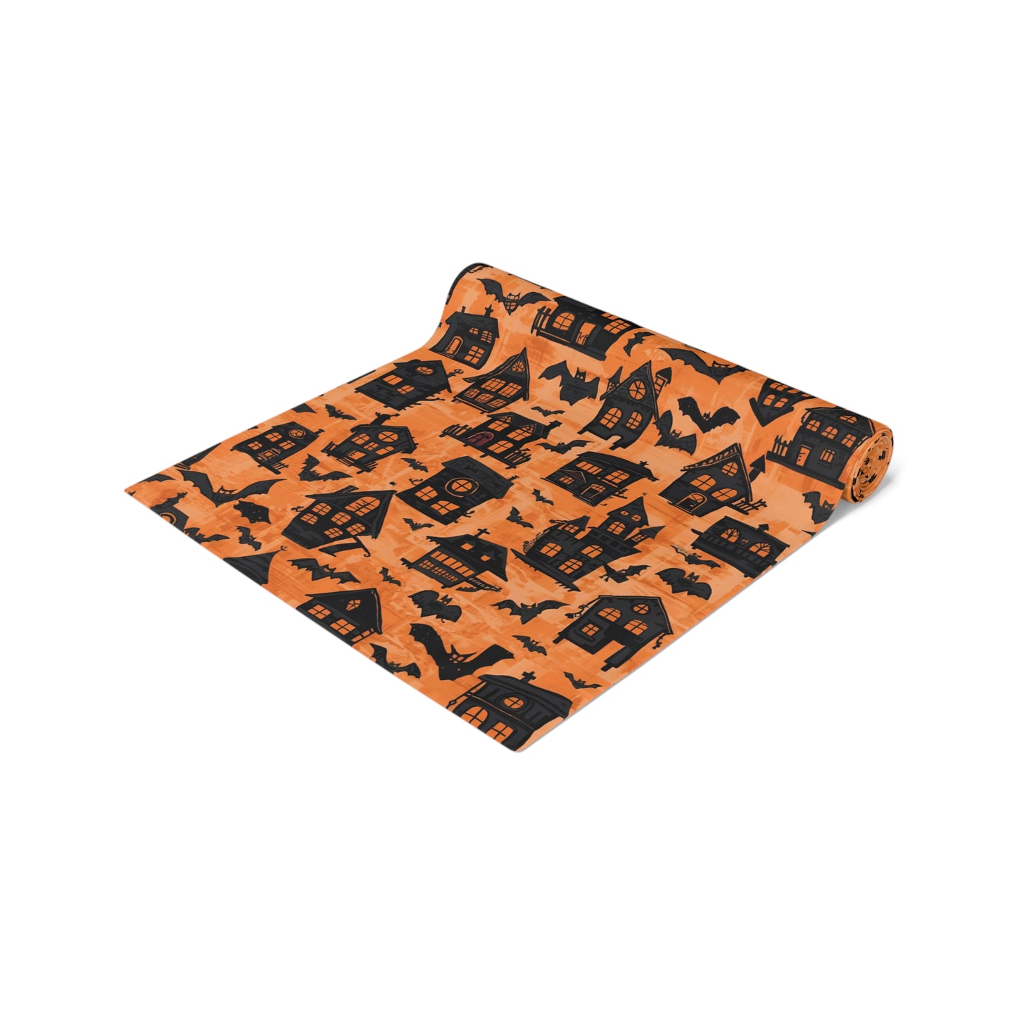 Black Haunted Houses table runner with black haunted houses and bats on an orange background design, printed on the table runner, rolled up on a white background 
