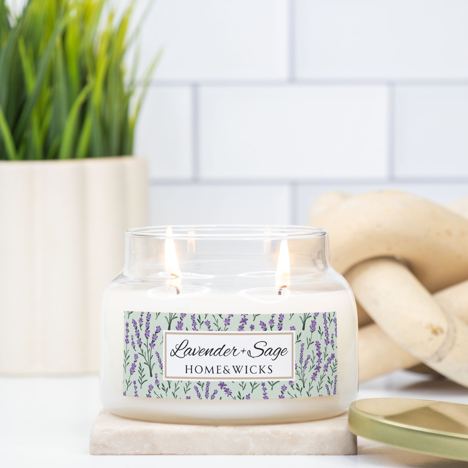 Candle with a 'Lavender & Sage' label on a marble surface with lavender flowers in the background.