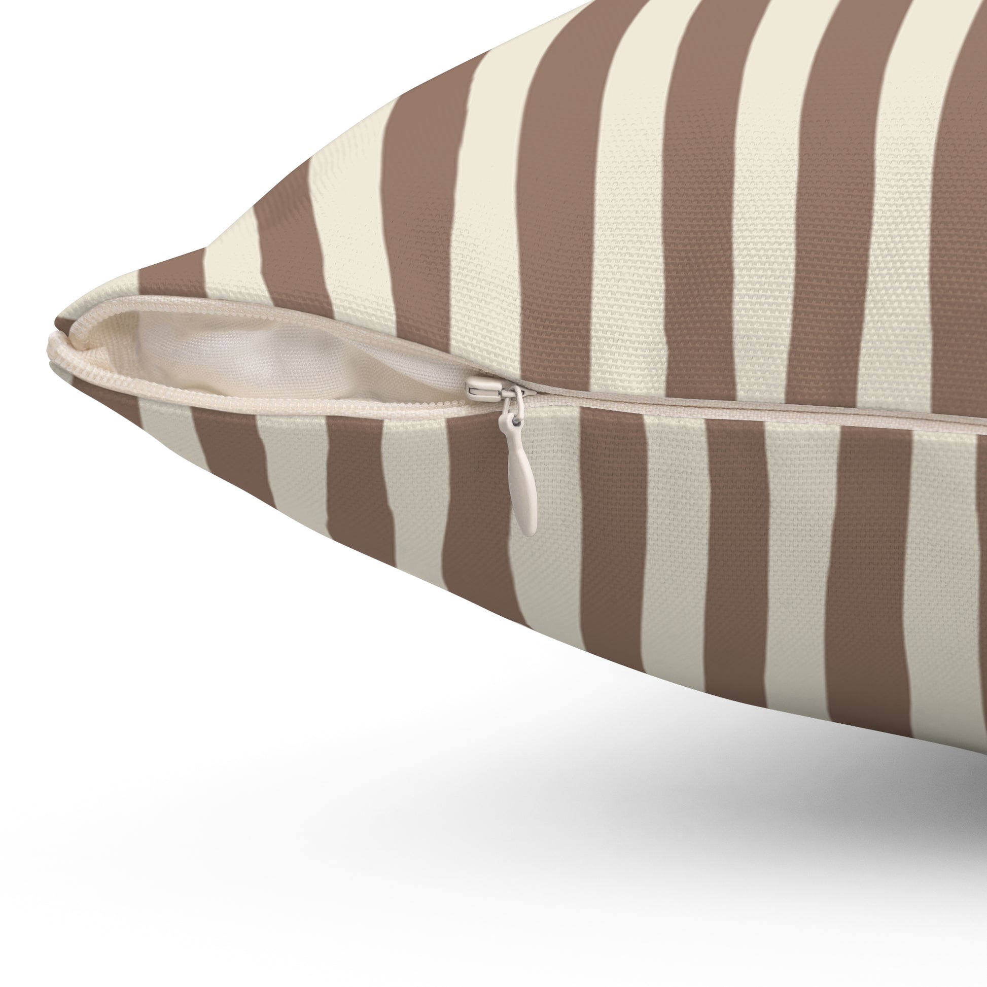 Close up of zipper closure on mocha brown striped pillow with brown and beige pattern on a white background