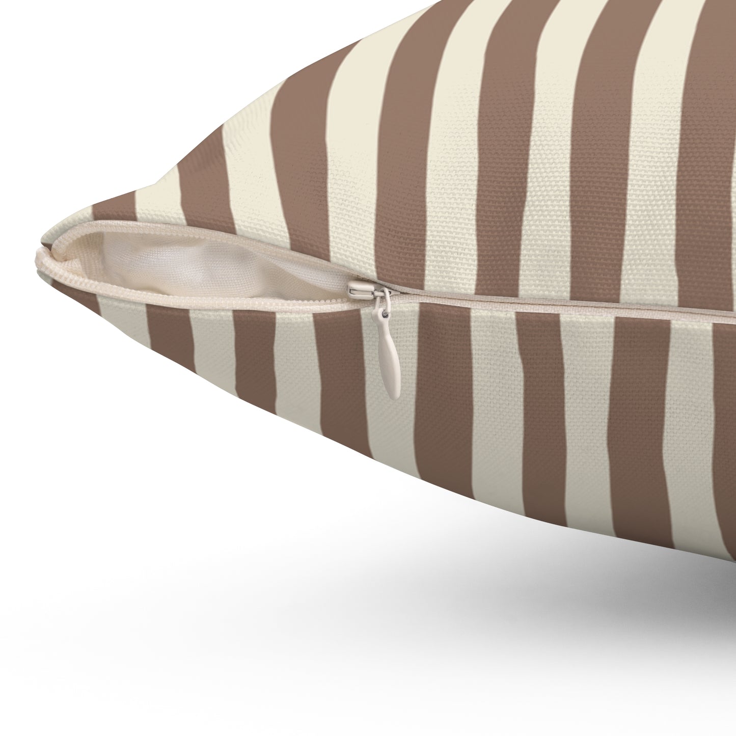 Close up of zipper closure on mocha brown striped pillow with brown and beige vertical stripes on a white background
