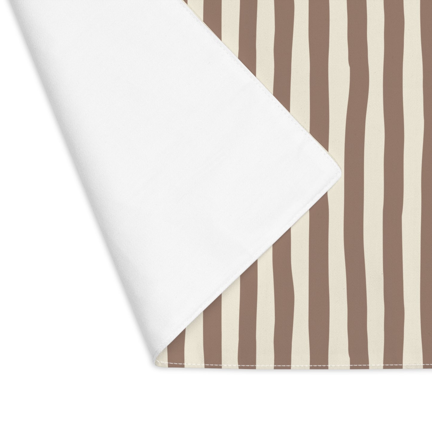 Brown and beige striped table runner with back corner lifted with a white background