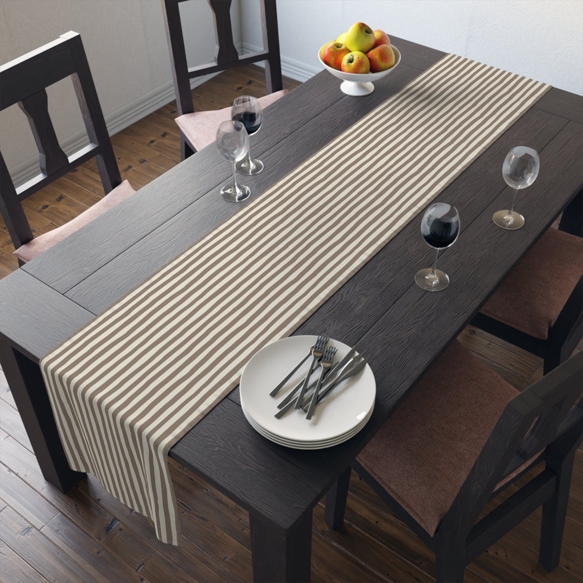 Dining table with brown and beige striped table runner, plates, and glasses in a home setting.