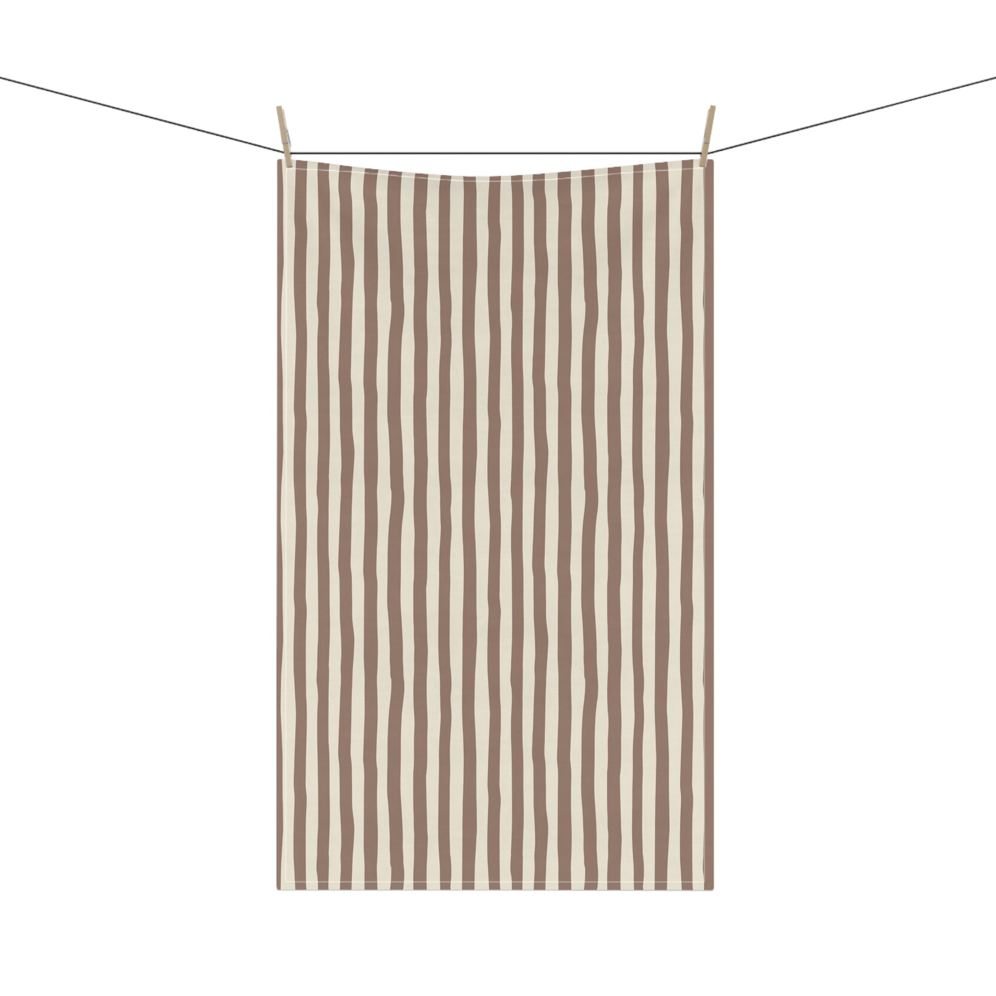 Mocha brown and beige striped towel hanging on a clothesline with a white background