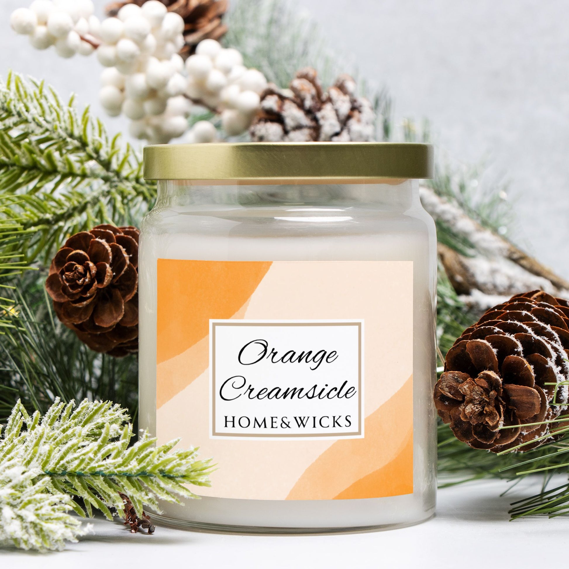 Candle jar labeled 'Orange Creamsicle' by Home & Wicks with decorative elements on a light background