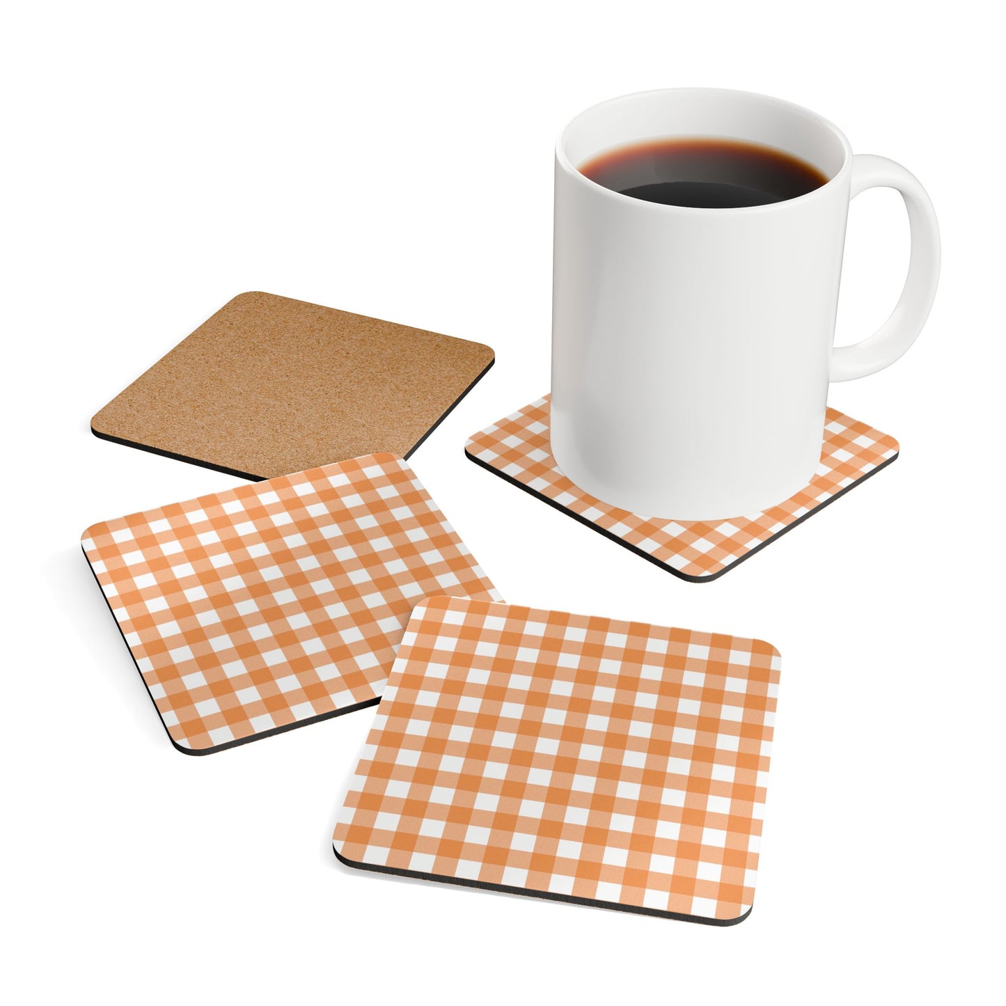 Set of four coasters with orange gingham checkered pattern, with coffee mug on top of one of the coasters, on a white background.