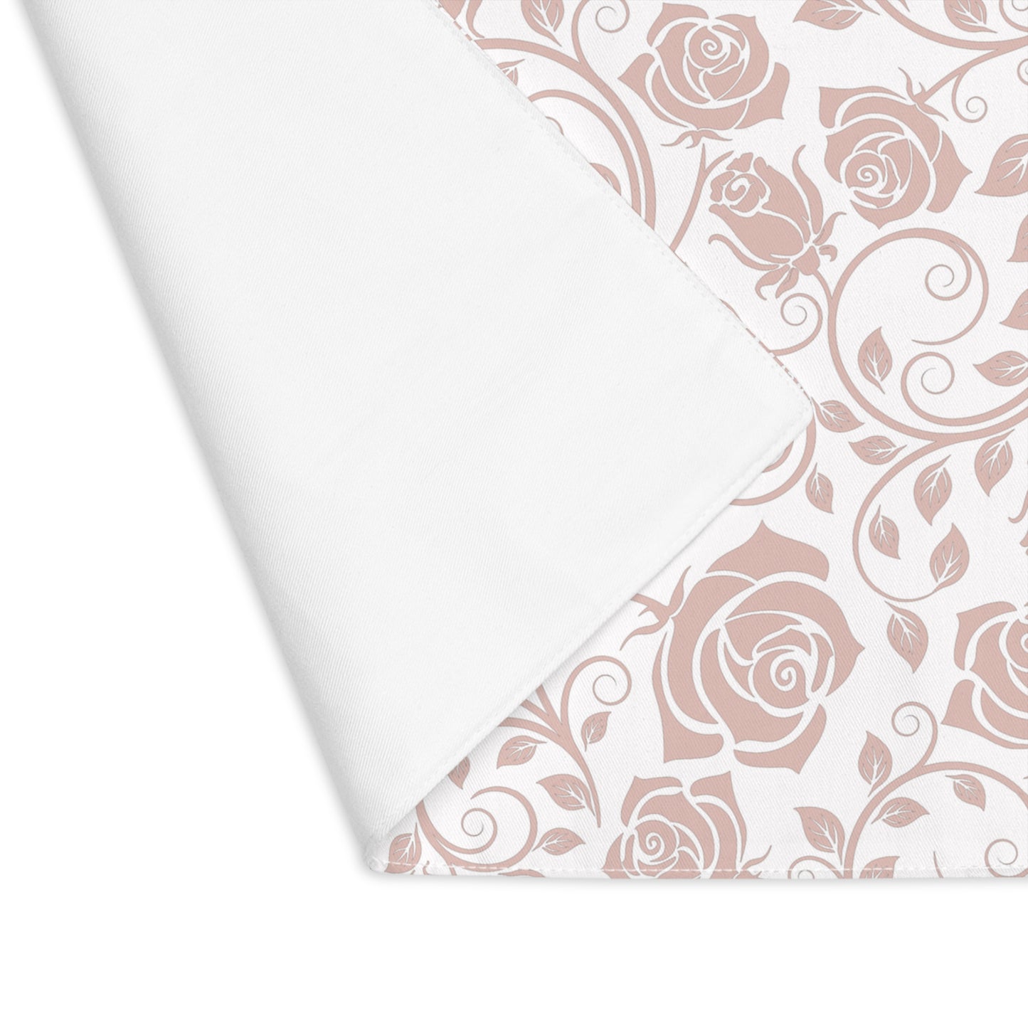 Pink rose floral pattern placemat on white background with corner folded over to reveal white background