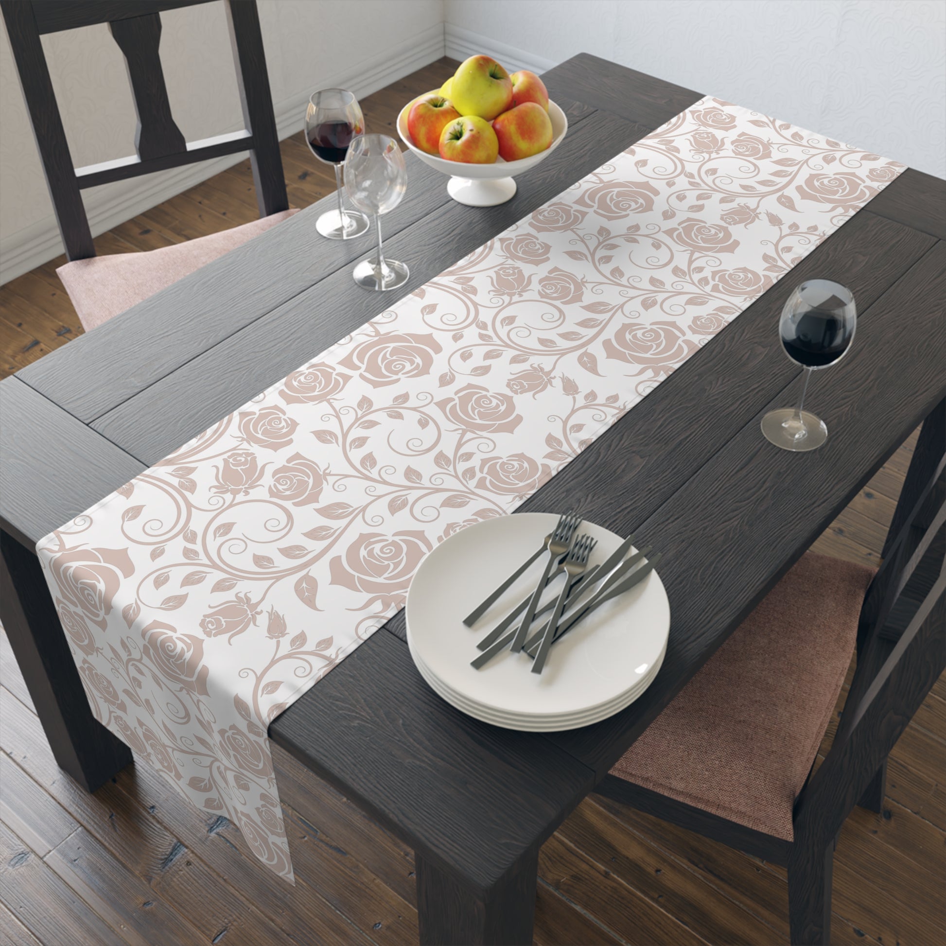 Dining table with a pink floral table runner, plates, cutlery, and fruit bowl.