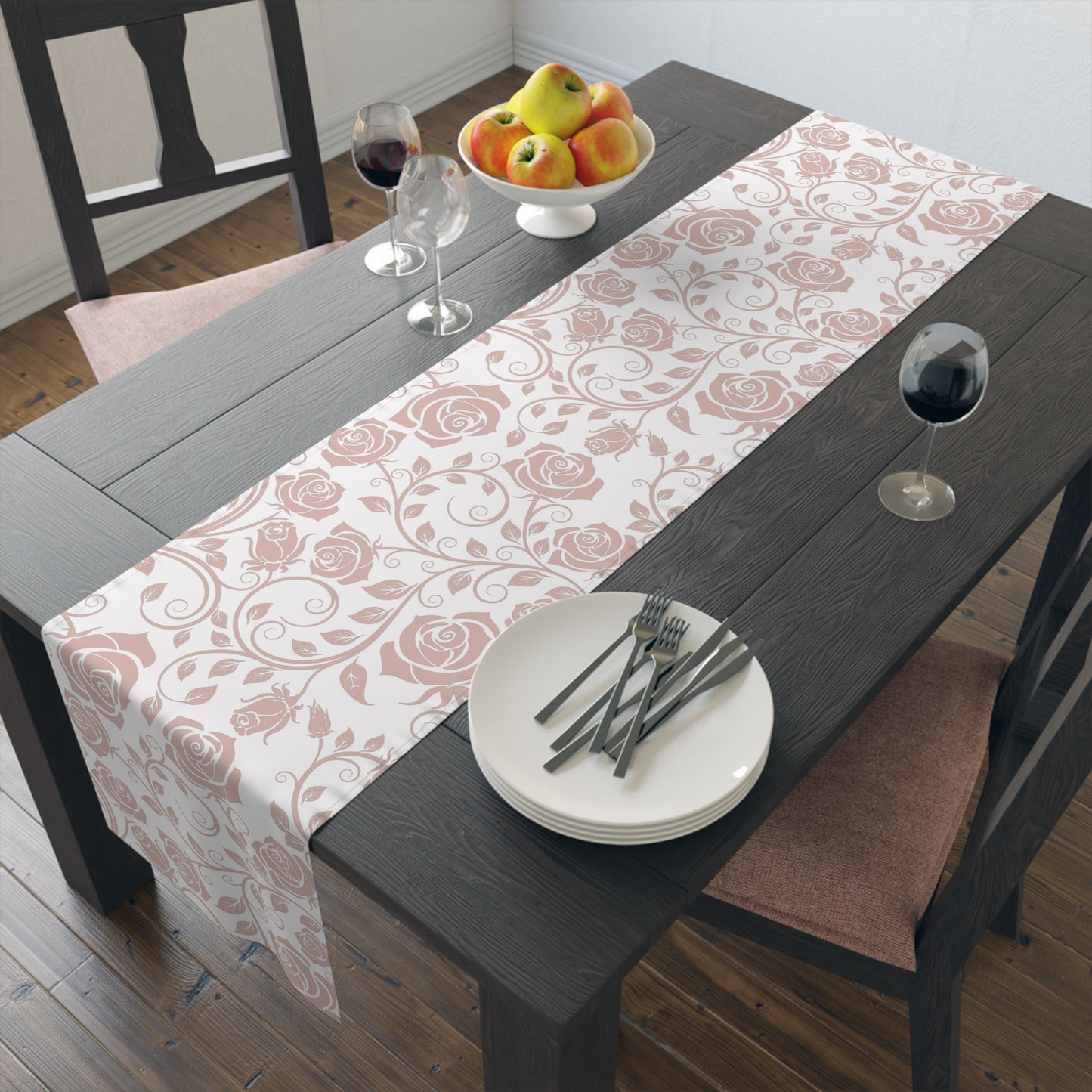 Dining table with a pink floral table runner, plates, cutlery, and fruit bowl.