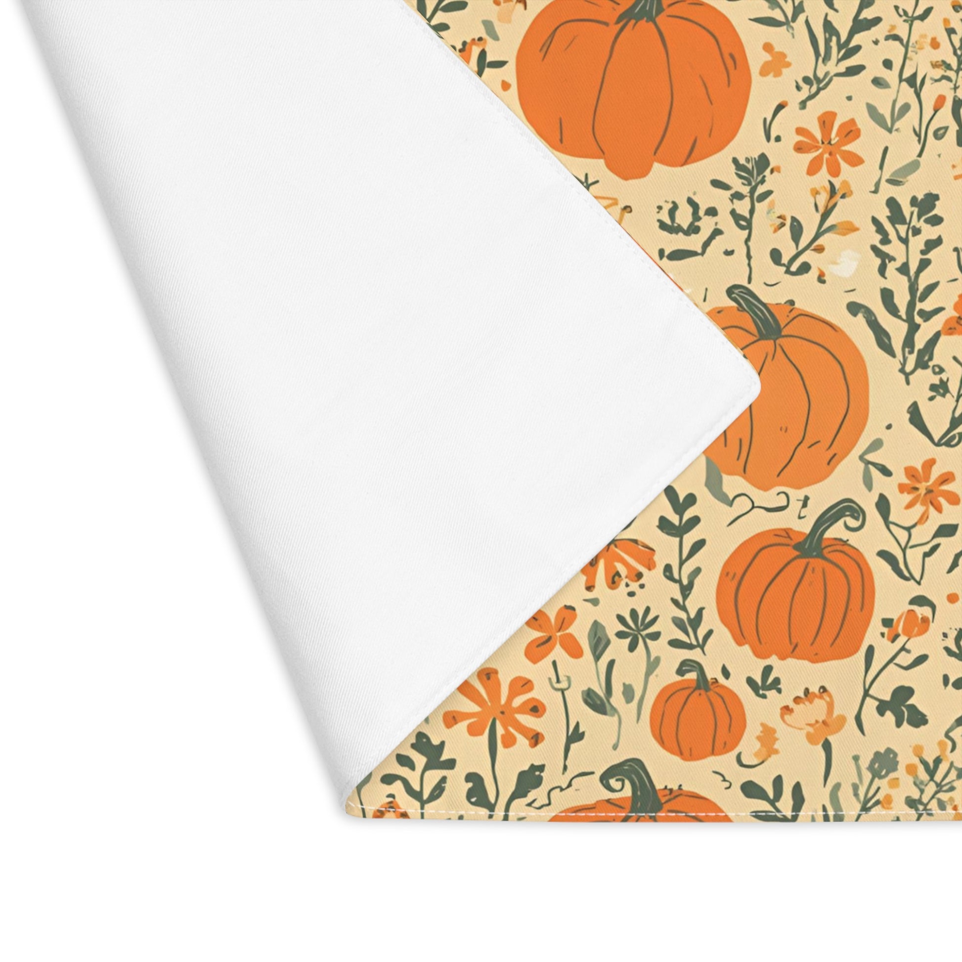 Our Pumpkin Garden cotton twill placemat has an orange pumpkins and flowers design with placemat edge folded over to reveal whit back