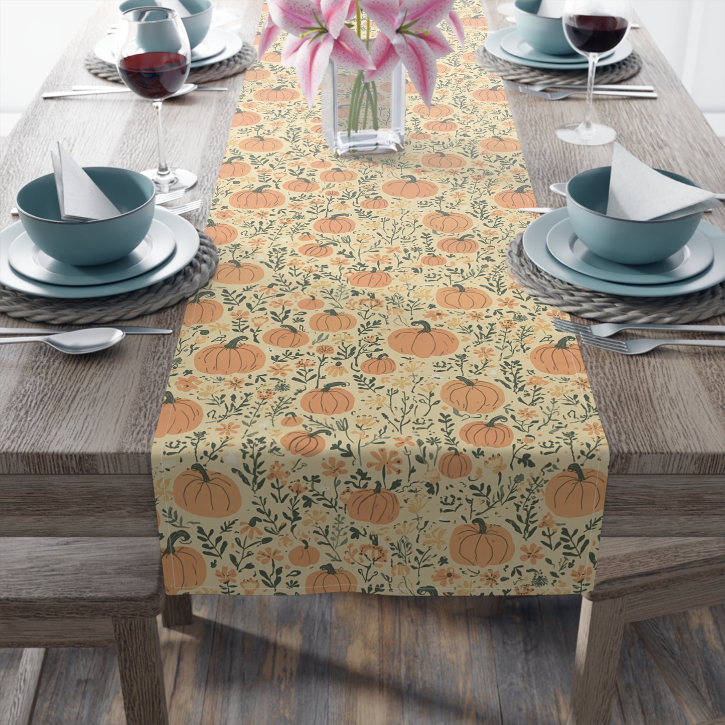 Our Pumpkin Garden table runner has an orange pumpkin and flowers table runner design on a table setting on a wooden table.