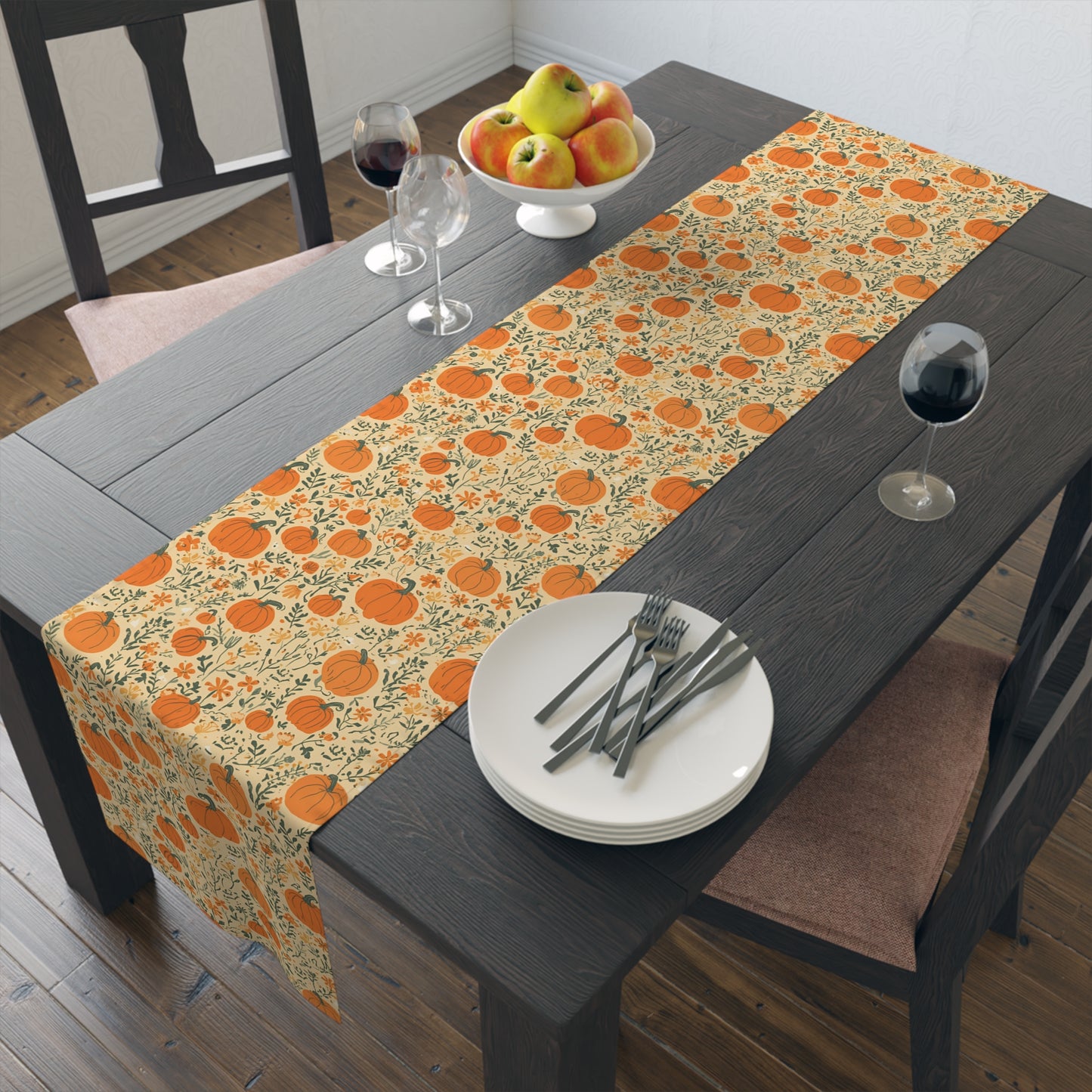 Our Pumpkin Garden table runner has an orange pumpkin and flowers table runner design and sits on a dining table plates, and cutlery.
