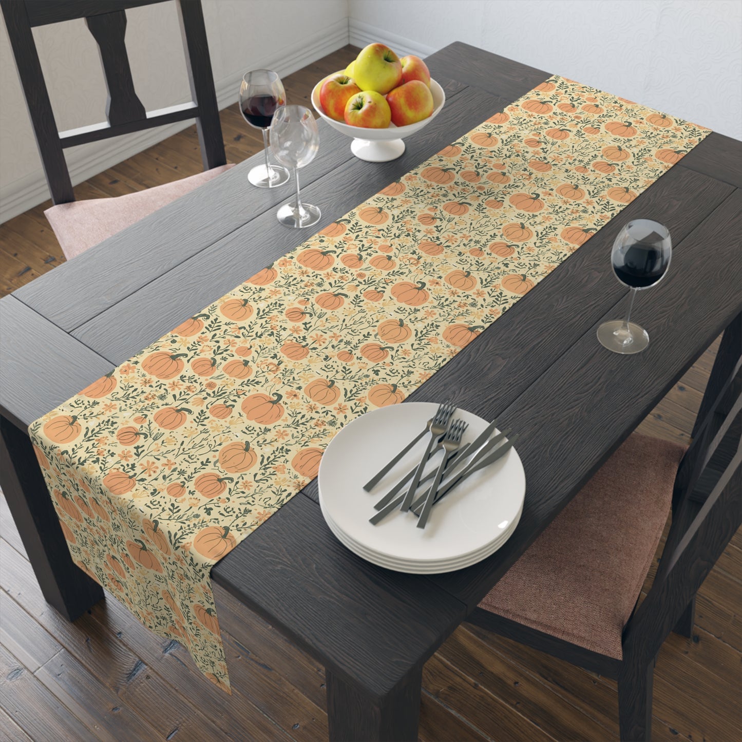 Our Pumpkin Garden table runner has an orange pumpkin and flowers table runner design and sits on a wooden table.