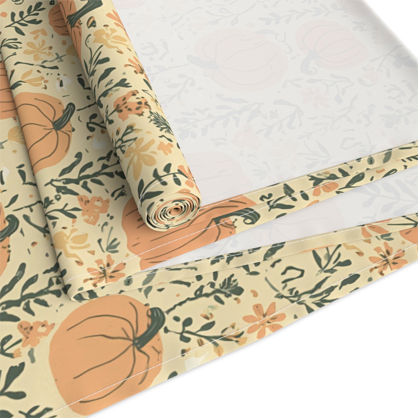 Our cotton twill Pumpkin Garden table runner has an orange pumpkin and flowers table runner design and is rolled up on a white surface