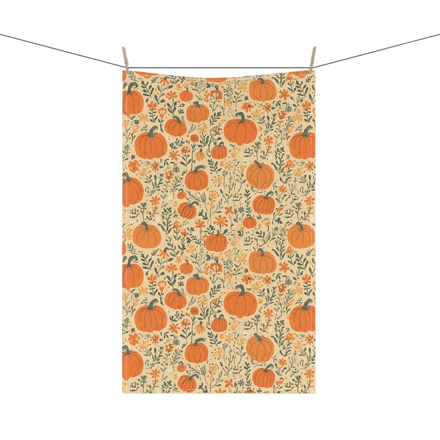 Tea towel with pumpkin and floral pattern hanging on a line