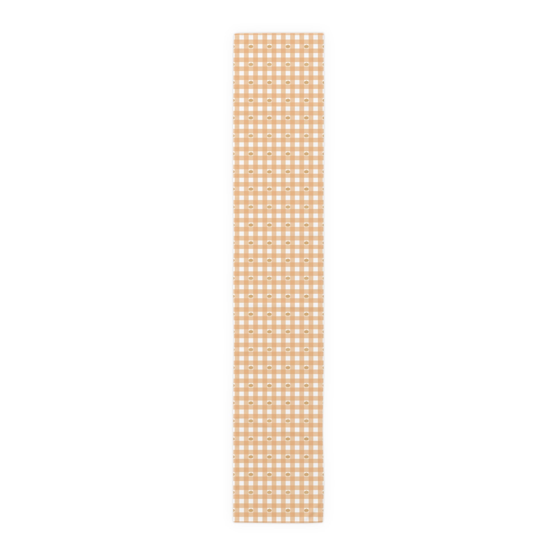 Our cotton twill 16" x 90" Pumpkin Gingham table runner has an orange and white checkered pattern with small pumpkins on the table runner fabric on a white background
