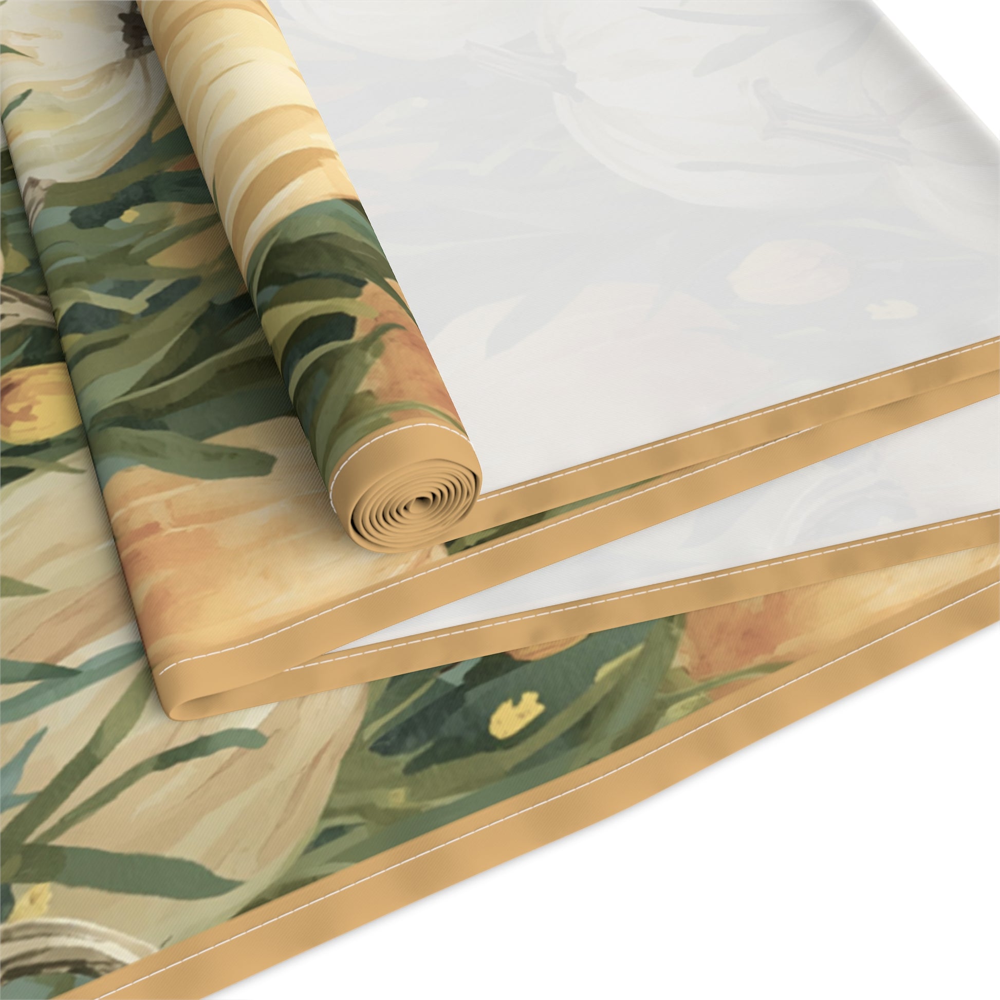 Pumpkin Patch table runner has white and orange pumpkins in grass with orange tulips printed on front of table runner cotton twill fabric that is rolled up and folded and sits on a white background