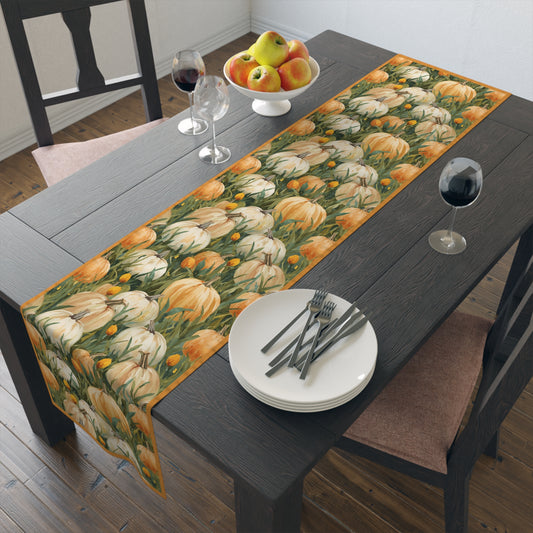 Pumpkin Patch table runner has white and orange pumpkins in grass printed on front of table runner polyester fabric and sits on a dining table set with plates, forks, and glasses.