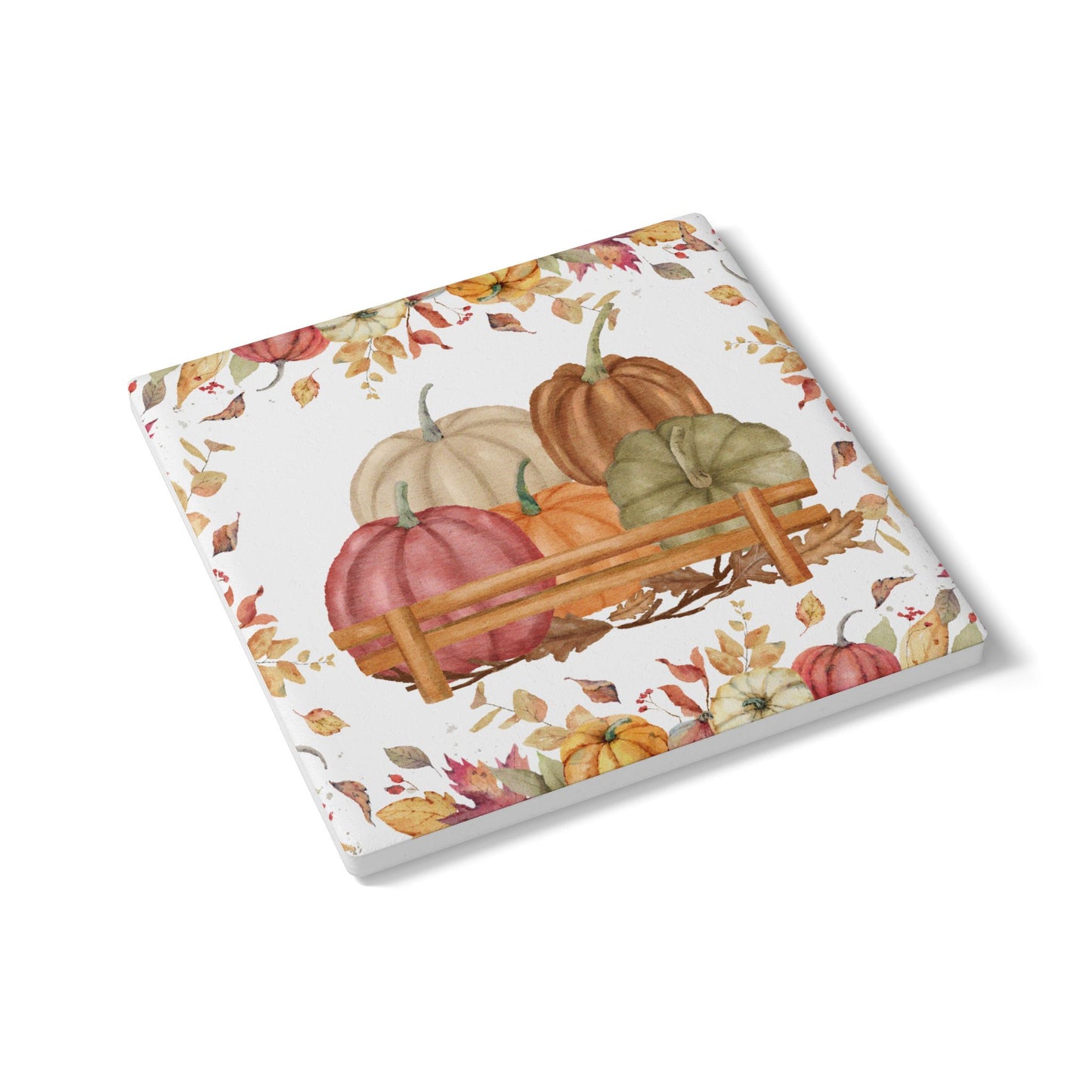 Ceramic tile coaster with autumn design featuring pumpkins and leaves on a white background