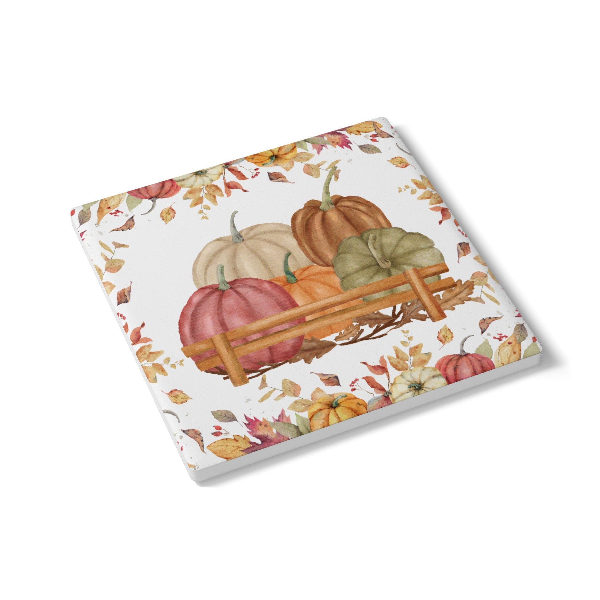 Ceramic tile coaster with autumn design featuring pumpkins and leaves on a white background