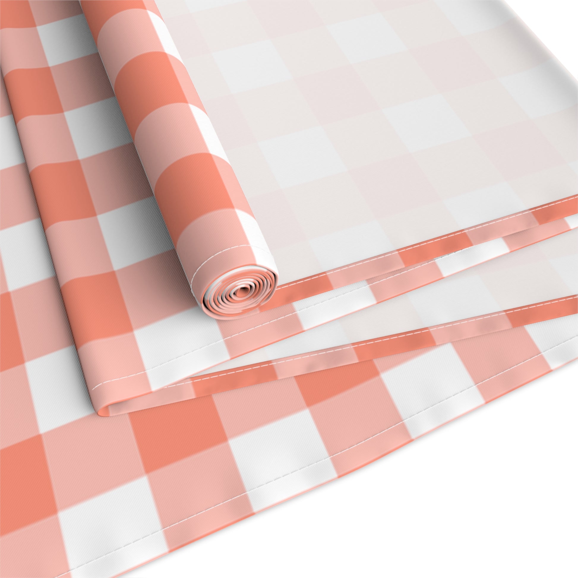 Red and white gingham checkered table runner rolled up and folded on a white background
