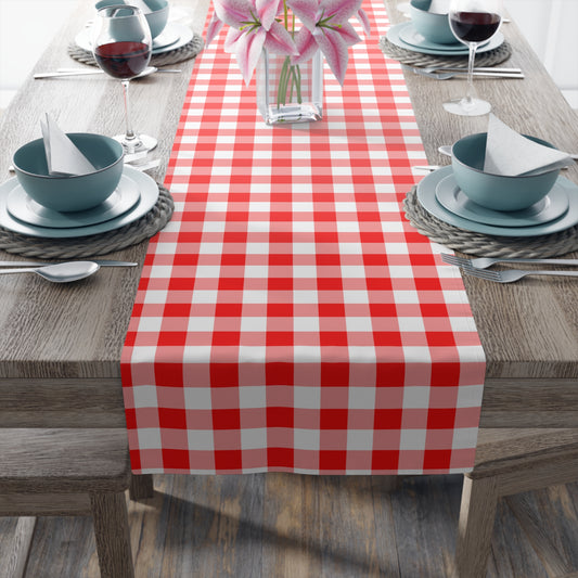 Red and white gingham checkered table runner on a wooden table with place settings.