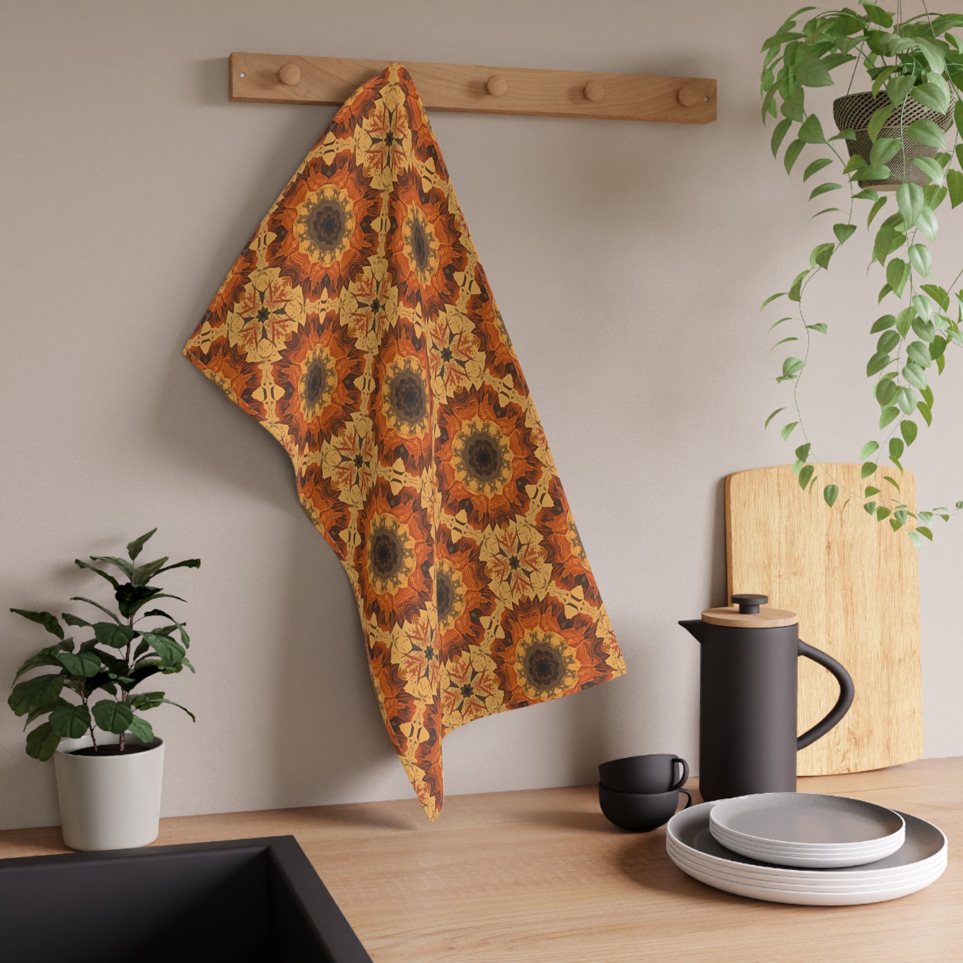 Decorative tye-dye fall flower patterned towel hanging on a wooden rack with kitchen items below.