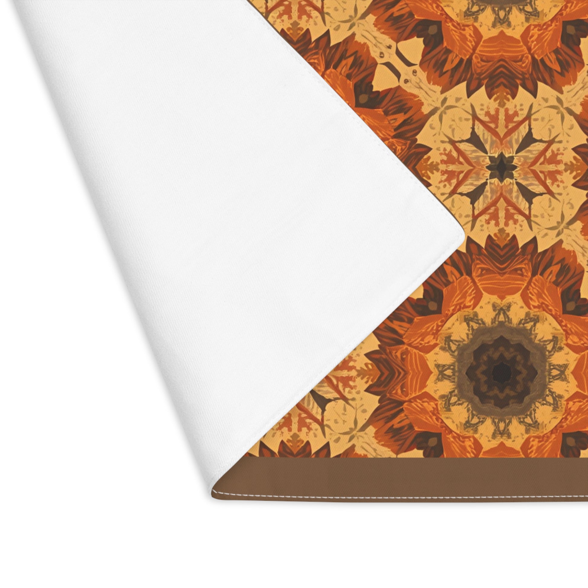 Retro Fall Flowers placemat has orange, yellow and gray geometric tye-dye floral pattern printed on the placemat's cotton twill fabric, with the corner of the placemat folded over revealing the white backside, on a white background