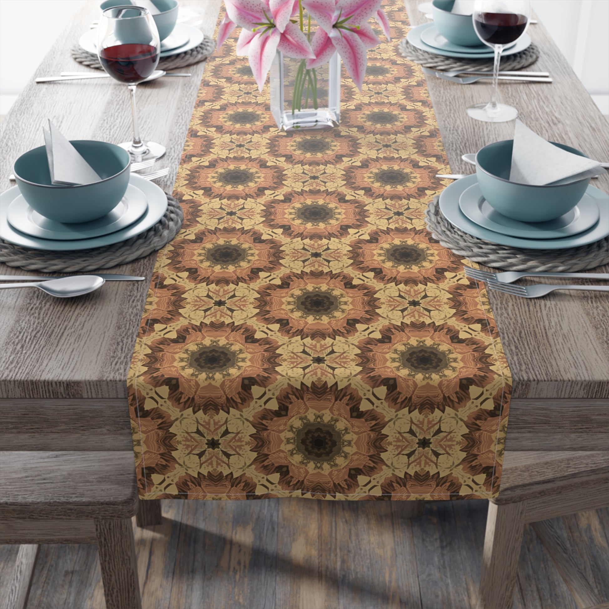 Dining table set with a orange, gray and yellow tye-dye patterned cotton table runner, bowls, and glasses.