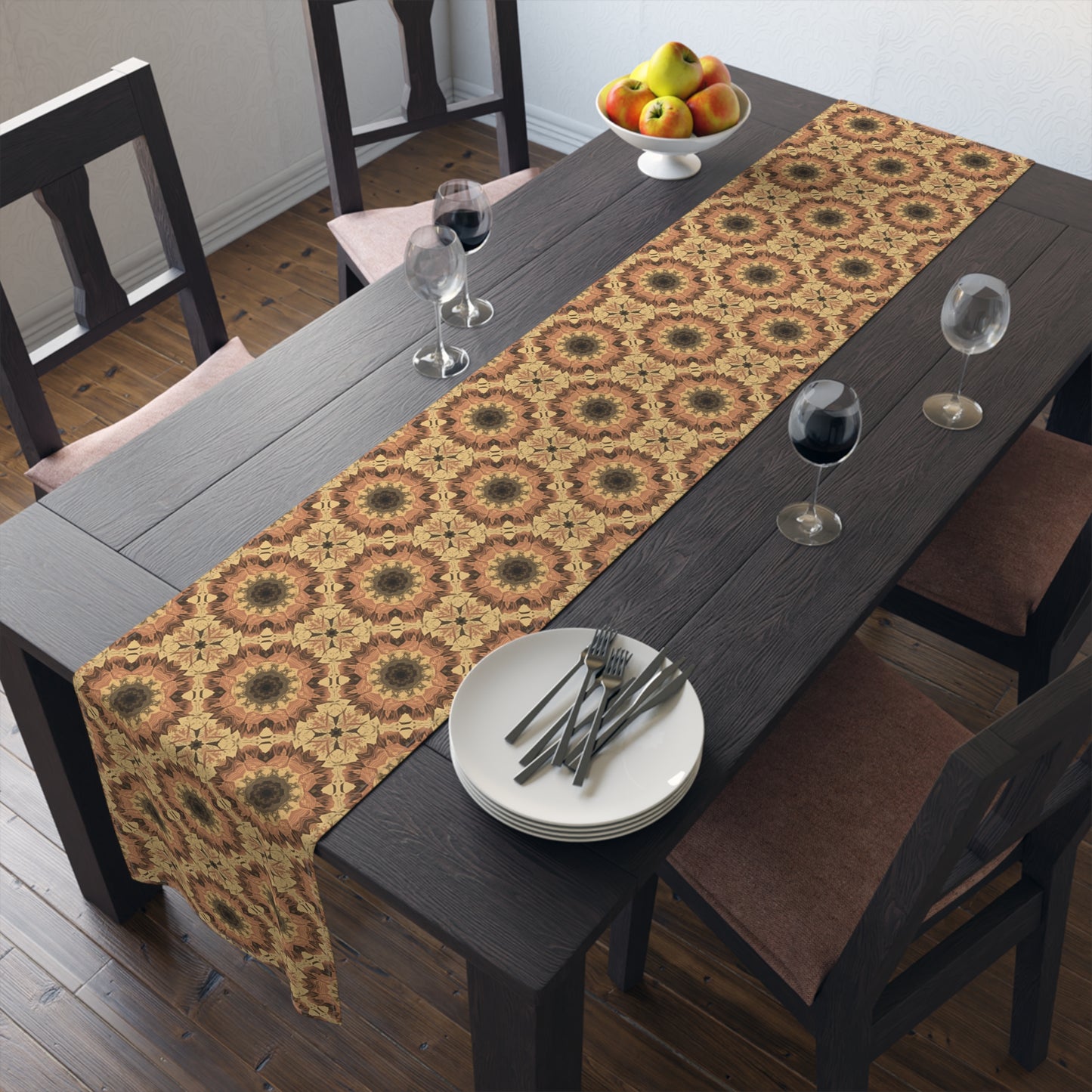 Dining table with an orange, gray and yellow tye-dye patterned cotton table runner, plates, and glasses in a home setting.