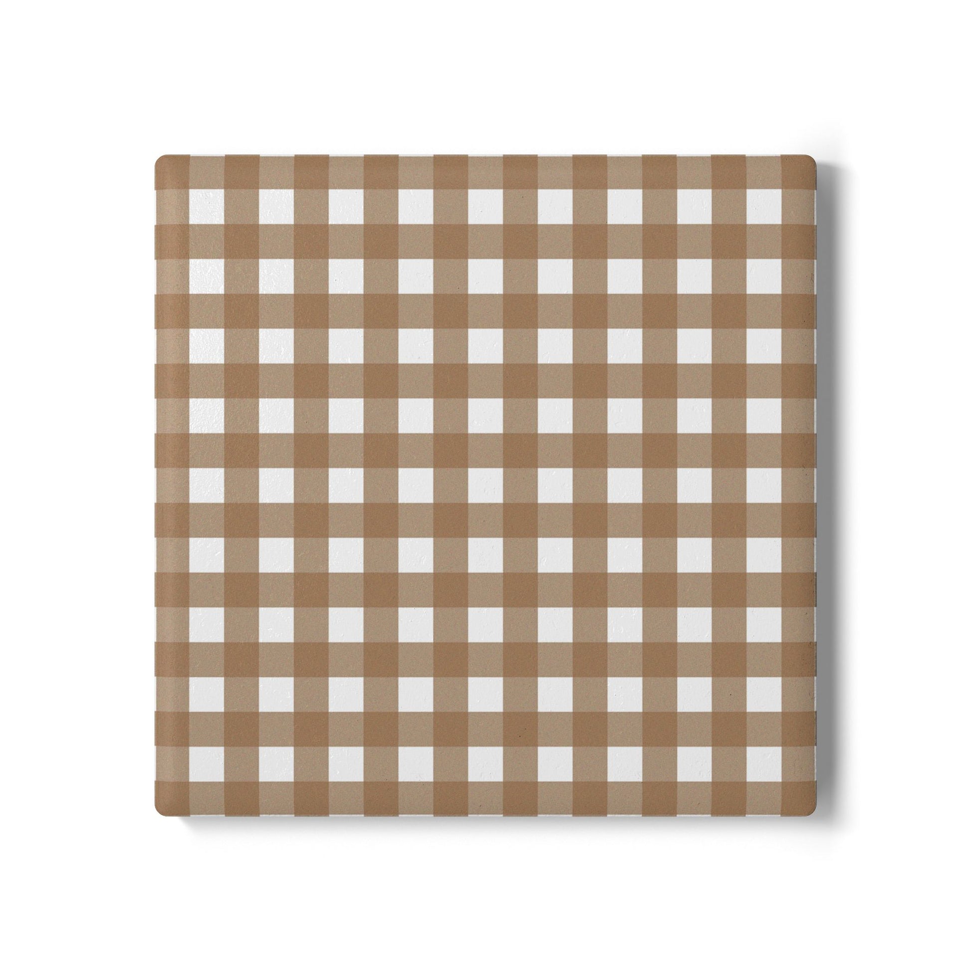Brown gingham checkered ceramic tile coaster on a white background
