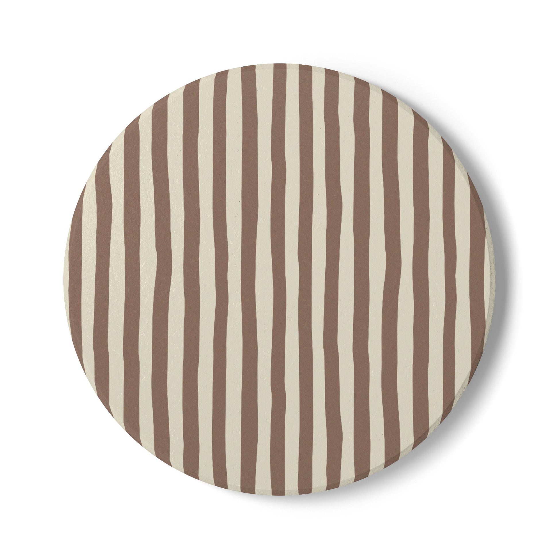 Round ceramic tile coaster with brown and beige vertical stripes on a white background