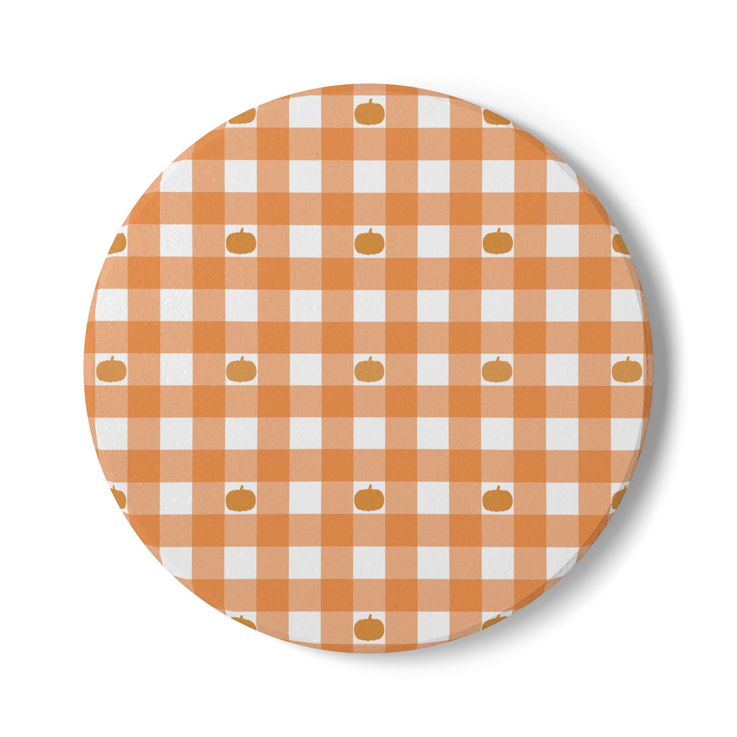 Round ceramic tile coaster with orange and white gingham checkered pattern and small pumpkin icons on a white background