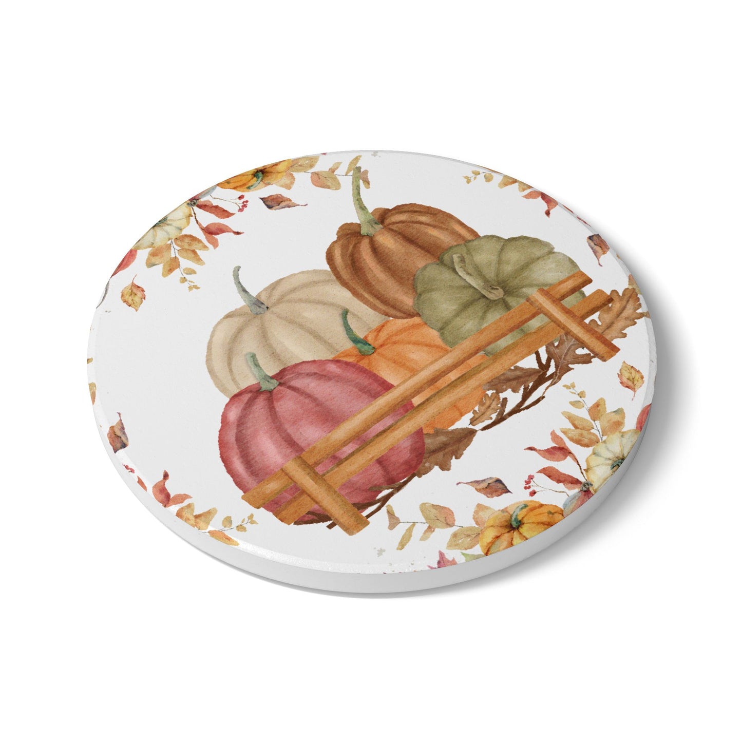 Round ceramic tile coaster with pumpkins and autumn leaves design on a white background