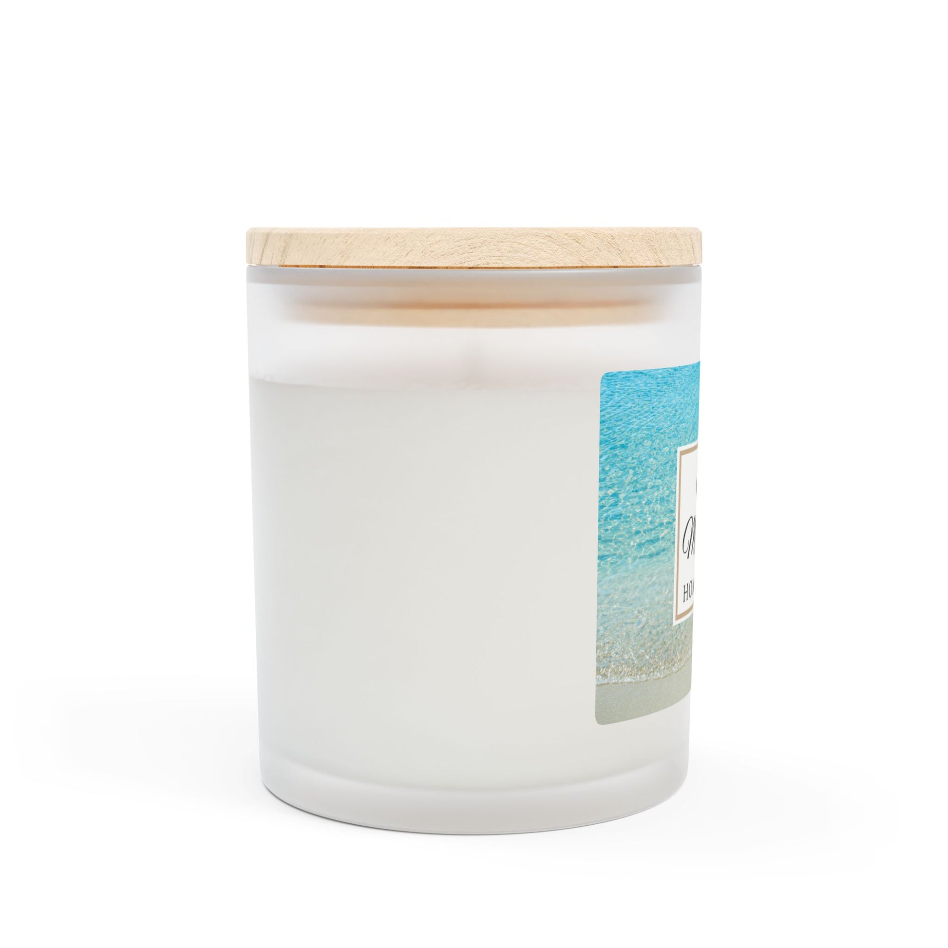 White candle with a wooden lid and beach-themed label on a white background