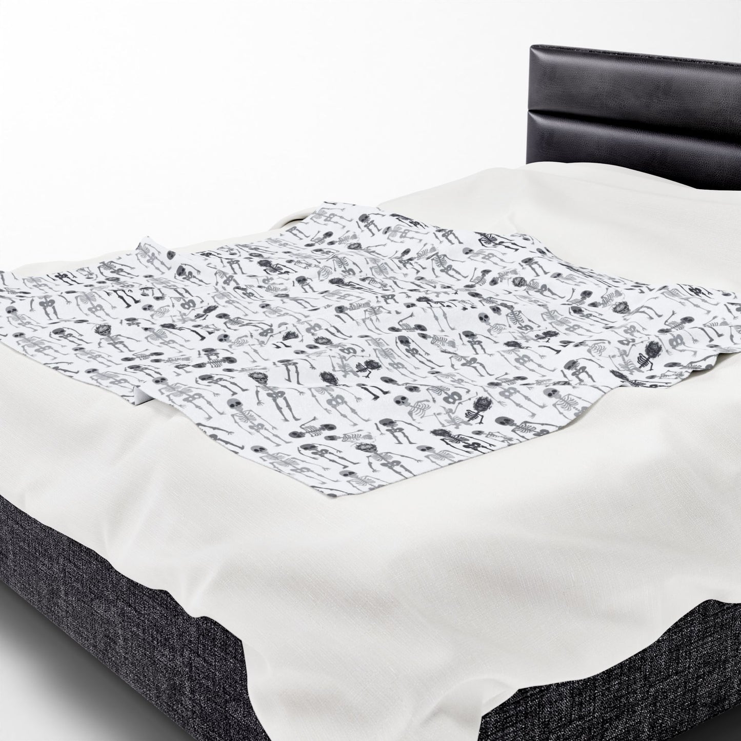 Halloween-themed Skeletons patterned blanket with black and white skeletons on a white background on front of blanket, on a white background