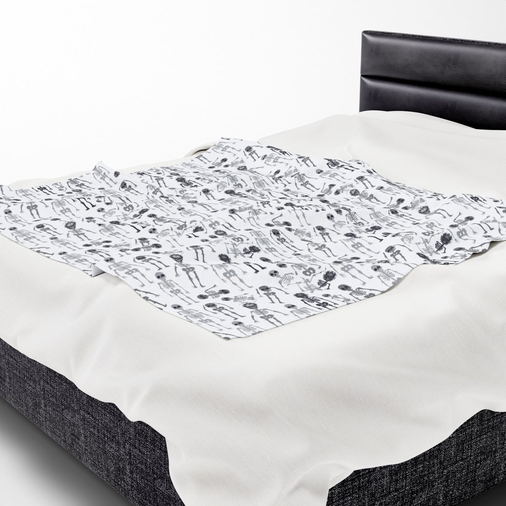 Halloween-themed Skeletons patterned blanket with black and white skeletons on a white background on front of blanket, on a white background