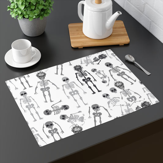 Skeletons placemat with black and white skeleton pattern on front of placemat, on a dark table with a teapot and cup.
