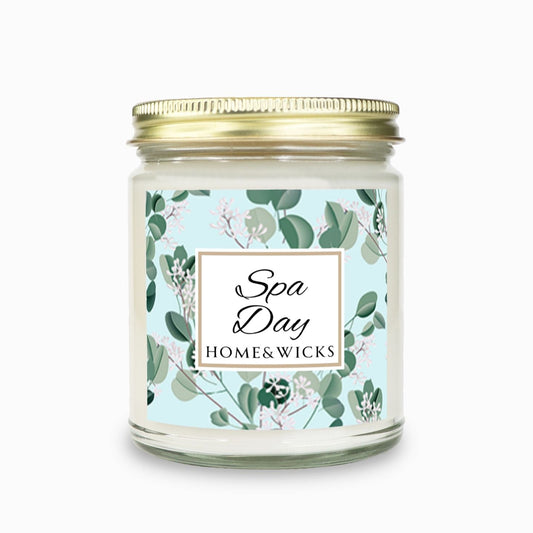 Spa Day candle clear jar with gold lid with a decorative eucalyptus label on a white background by Home & Wicks