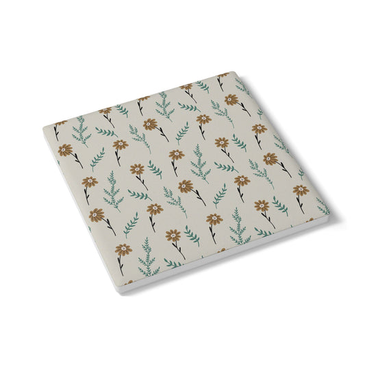 Ceramic tile coaster with brown floral pattern with a gray background on a white background