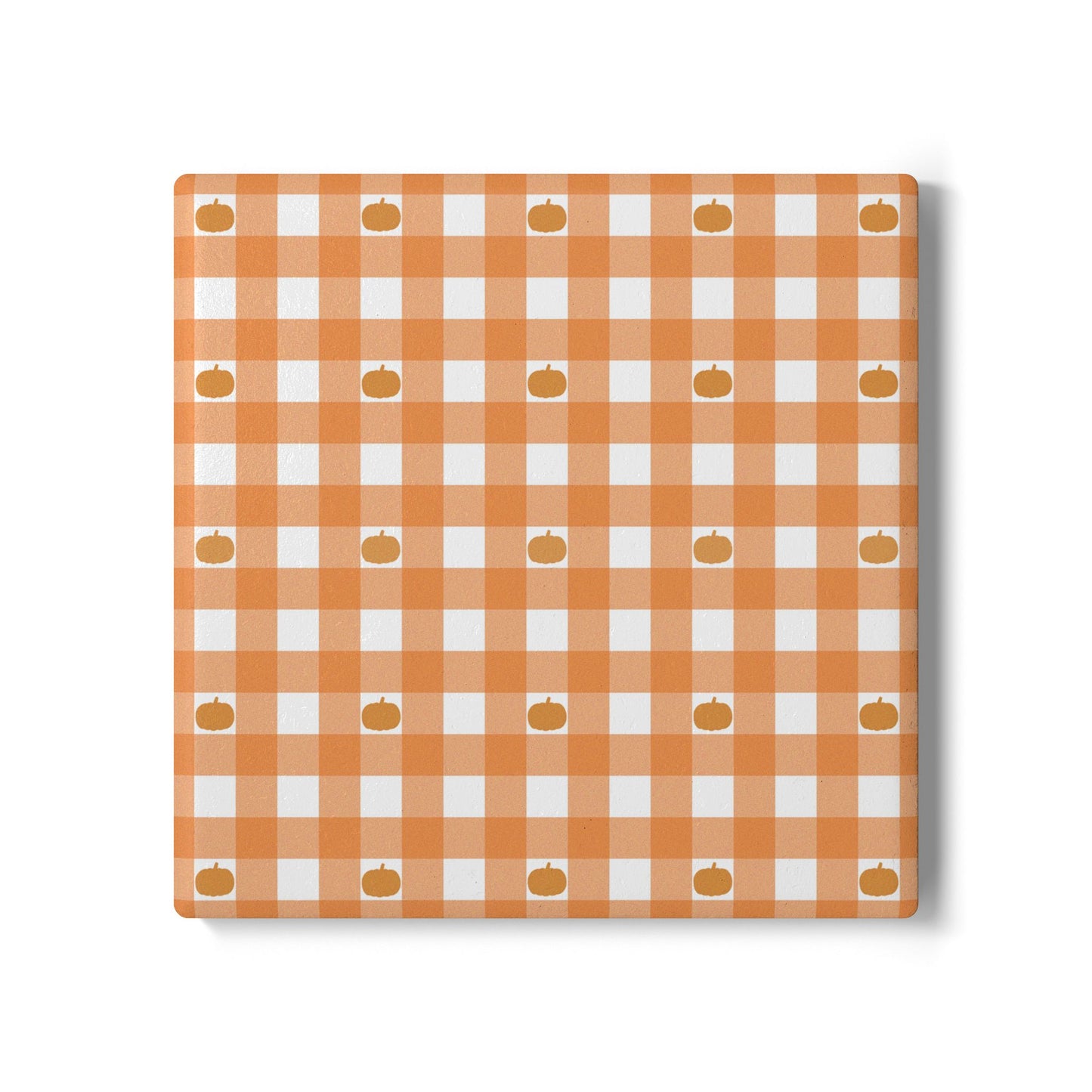 Checkered orange gingham with small pumpkins pattern on a square ceramic tile coaster on a white background.