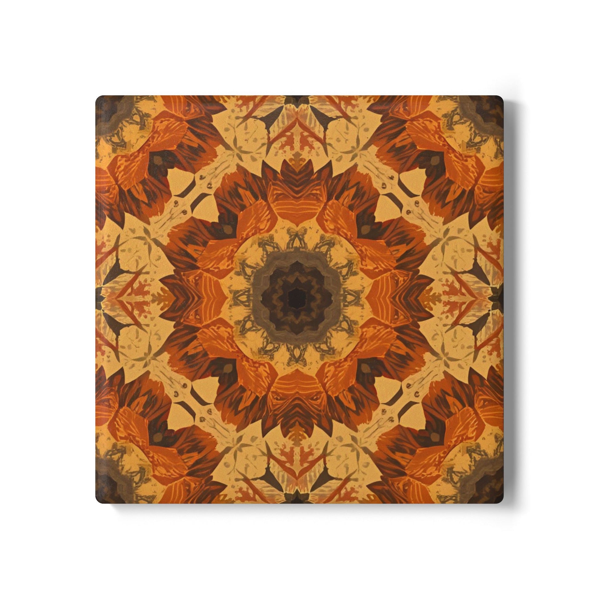 Square tile coaster with orange, gray and yellow mandala pattern with warm colors on a white background