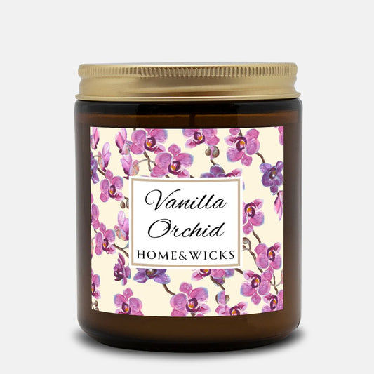 Vanilla Orchid candle in an amber jar with gold lid with a pink and purple orchid design label by Home & Wicks