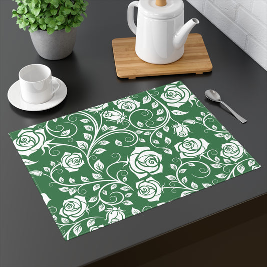 Green placemat with white floral pattern on a dark surface with tea set.